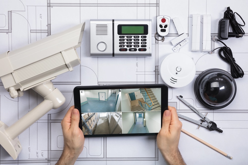 Hands holding a tablet with security camera footage